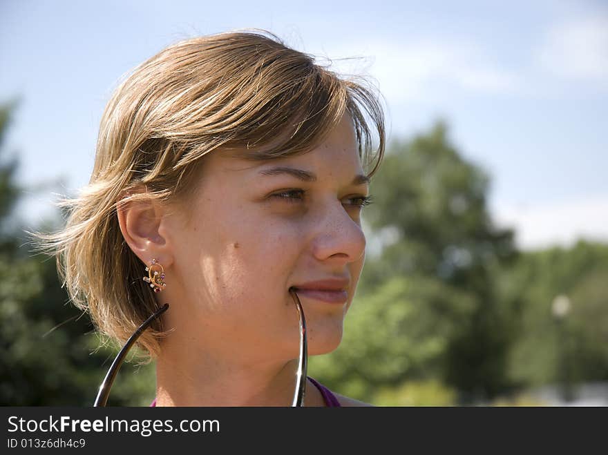 Outdoor portrait of one young clam girl holding glasses. Outdoor portrait of one young clam girl holding glasses