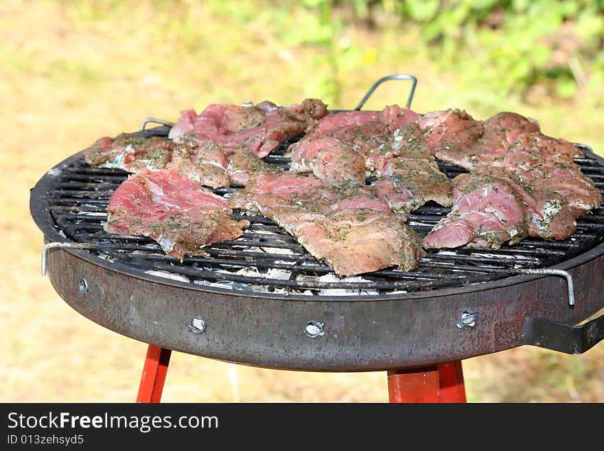 Seasoned strip steaks on a grill ready for cooking. Seasoned strip steaks on a grill ready for cooking