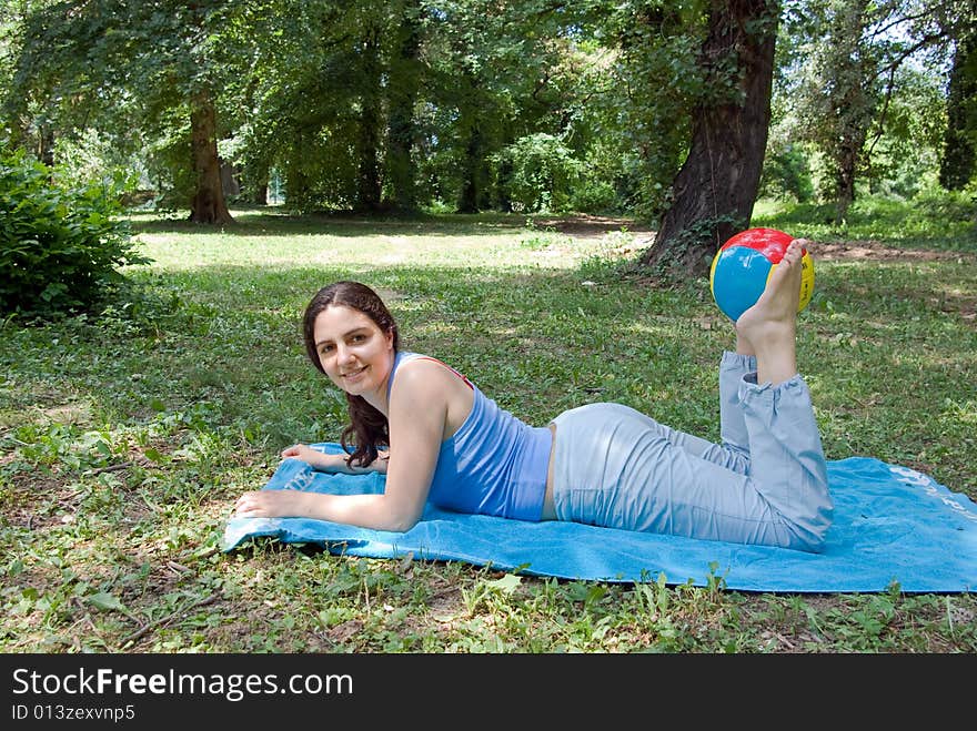 Pretty girl exercising with ball outside