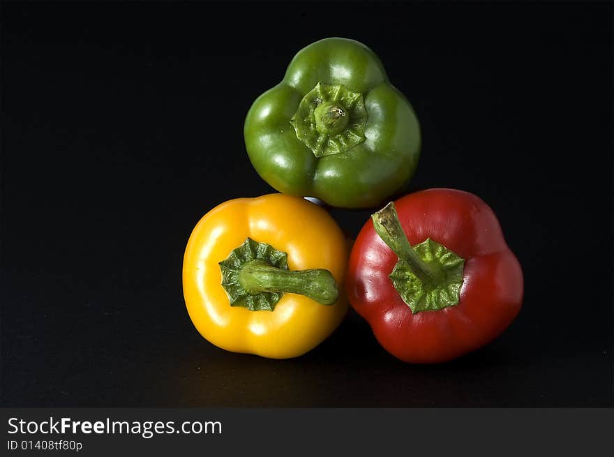 Close up of Red Yellow Orange and Green Peppers on a dark background. Close up of Red Yellow Orange and Green Peppers on a dark background