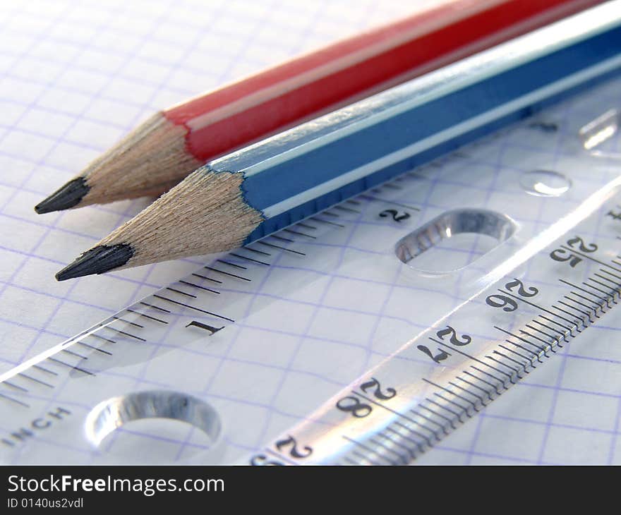 Two pencils and a ruler on the workbook page. Two pencils and a ruler on the workbook page