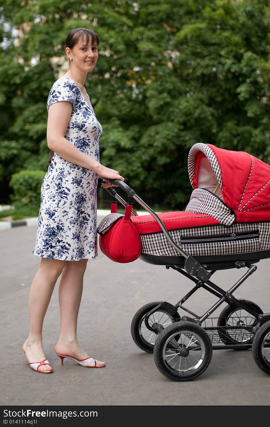 Young woman with red baby carriage. Young woman with red baby carriage