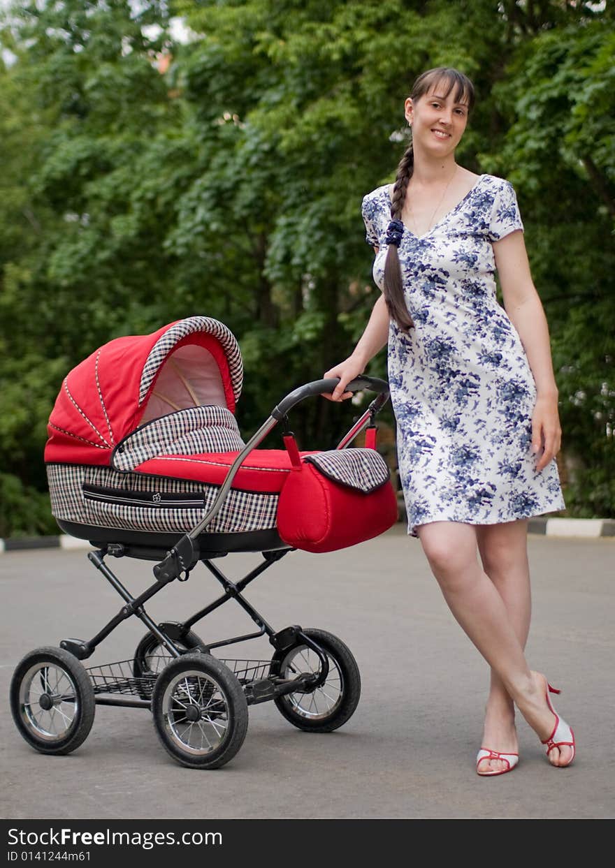 Young woman with red baby carriage. Young woman with red baby carriage