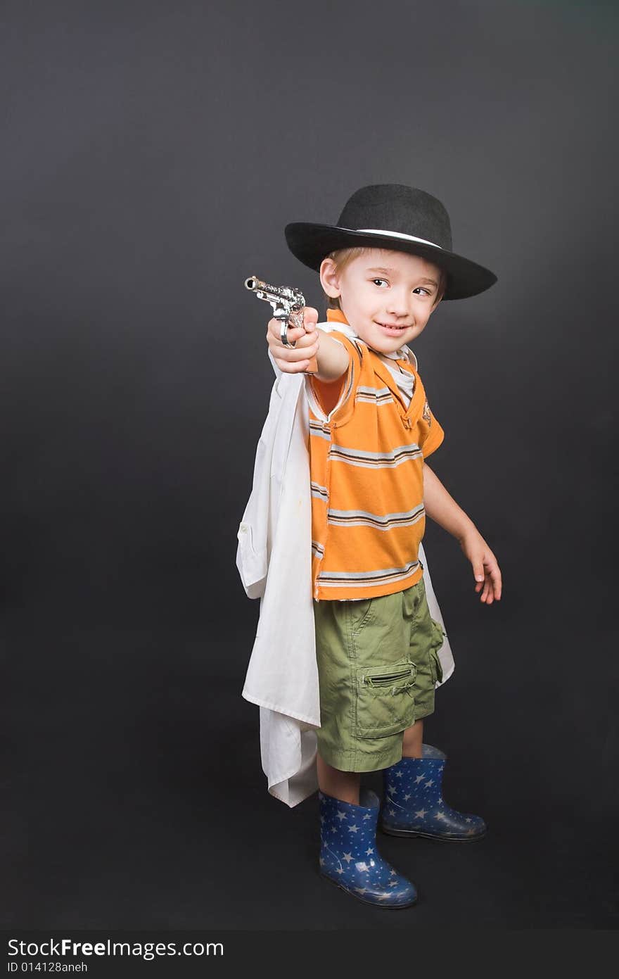 Young boy playing dressed up in hat and cape. Young boy playing dressed up in hat and cape