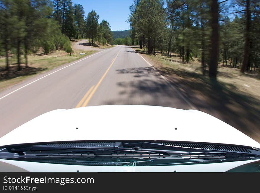 An image a view of a mountain road from inside a car. An image a view of a mountain road from inside a car