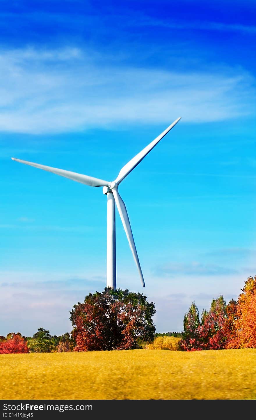 Wind turbine in autumnal landscape with blue sky. Wind turbine in autumnal landscape with blue sky