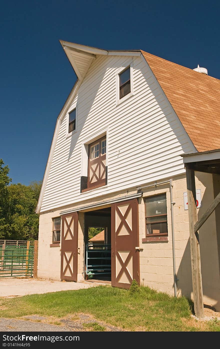 A view of a classic gambrel style country barn on a small dairy farm. A view of a classic gambrel style country barn on a small dairy farm.