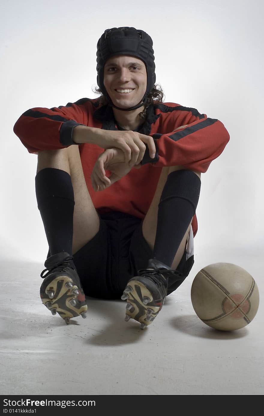 A rugby player pictured with a rugby ball.  He is looking at the camera, and is smiling.  Vertically framed shot. A rugby player pictured with a rugby ball.  He is looking at the camera, and is smiling.  Vertically framed shot.