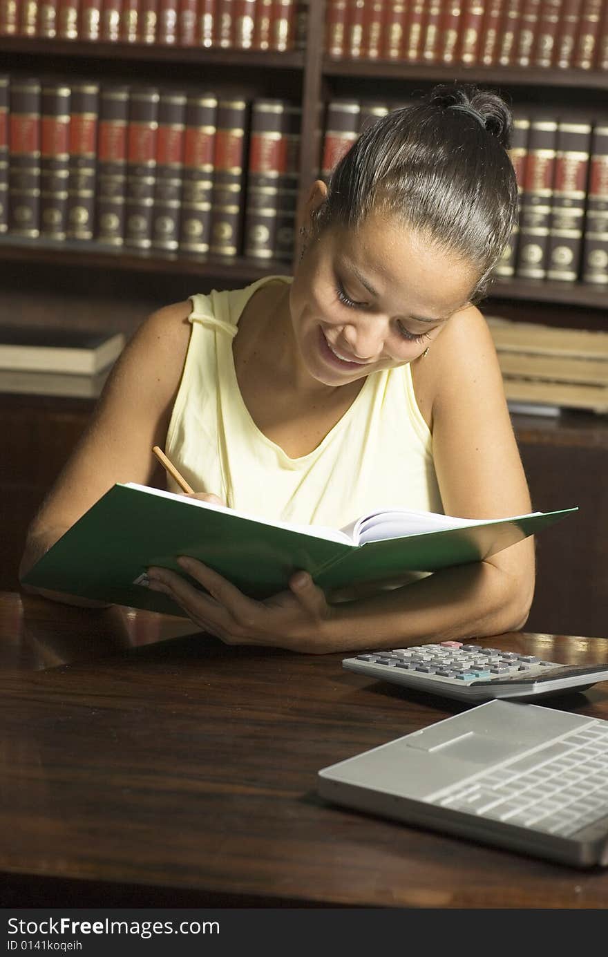 Woman in office smiling as she looks at notebook. Vertically framed photo. Woman in office smiling as she looks at notebook. Vertically framed photo.