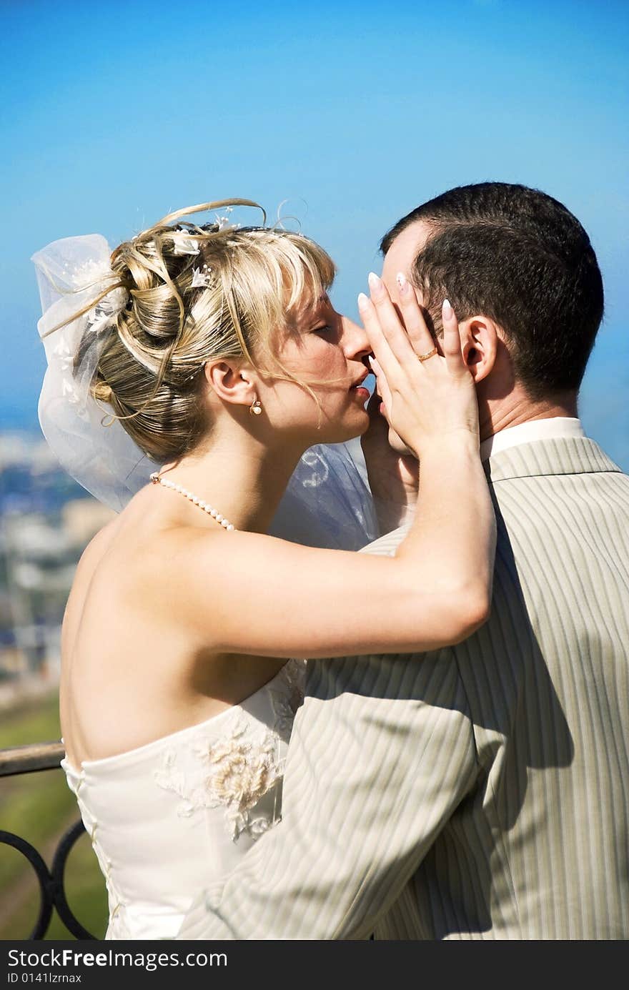 Happy bride and groom outdoor against blue sky