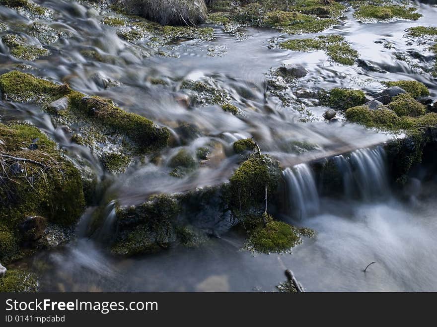 Stream flowing through some pooling ponds with a glassy effect created by a longer exposure time.