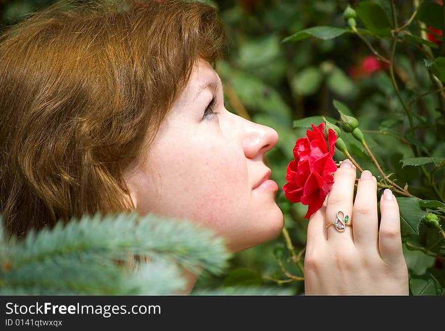 The girl smells a rose bud