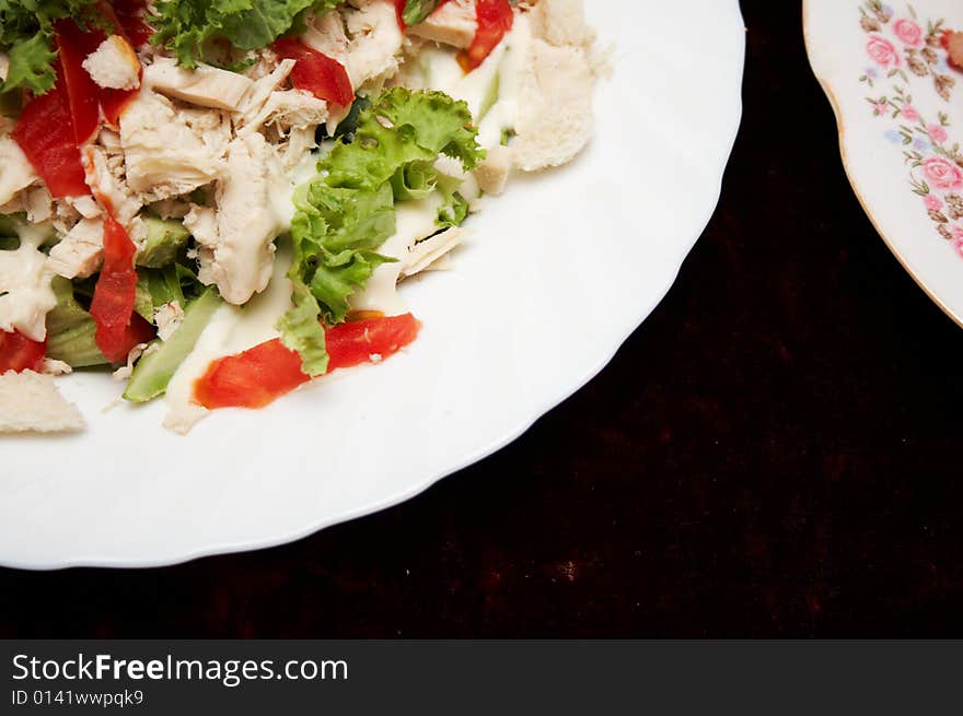 Salad from meat and vegetables on the white plate. Salad from meat and vegetables on the white plate