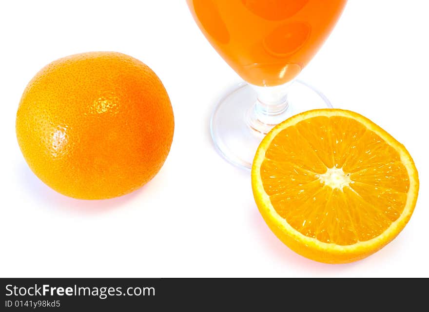 Orange juice in glass and oranges.