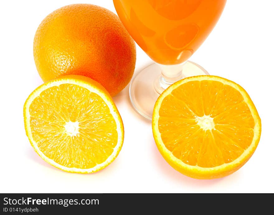 Orange juice in glass and oranges.