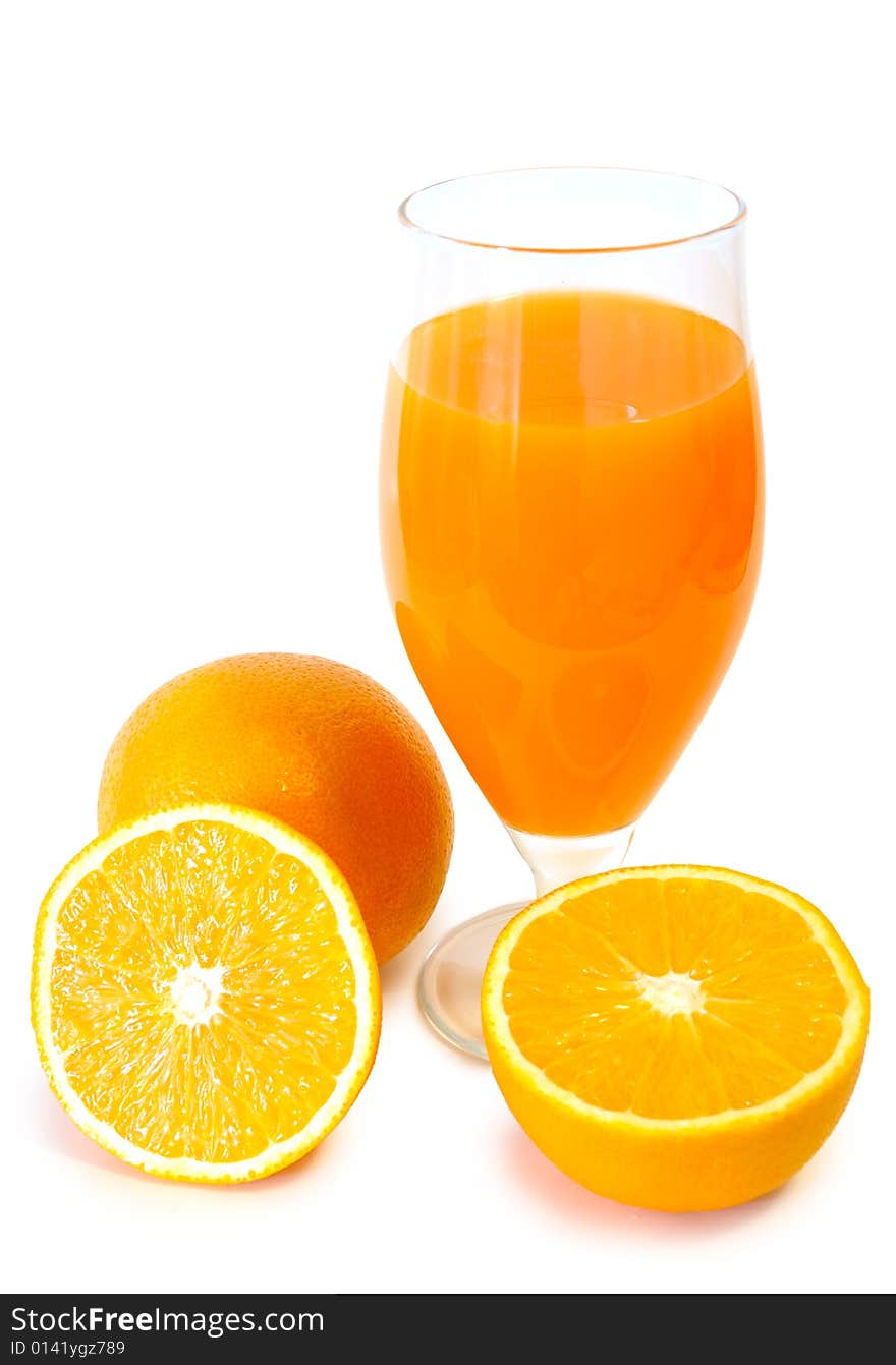 Orange juice in glass and oranges.