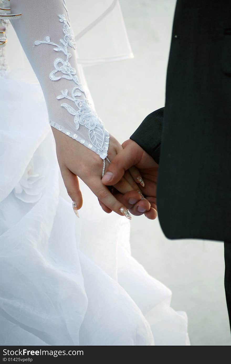 The groom holds the bride for a hand. The groom holds the bride for a hand