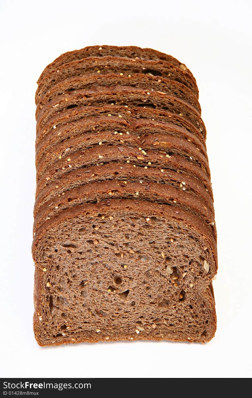 Stack of sliced wheat bread on white table.