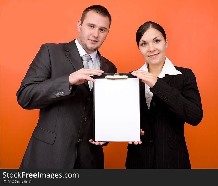 Businesspeople holding blank paper on orange background. Businesspeople holding blank paper on orange background