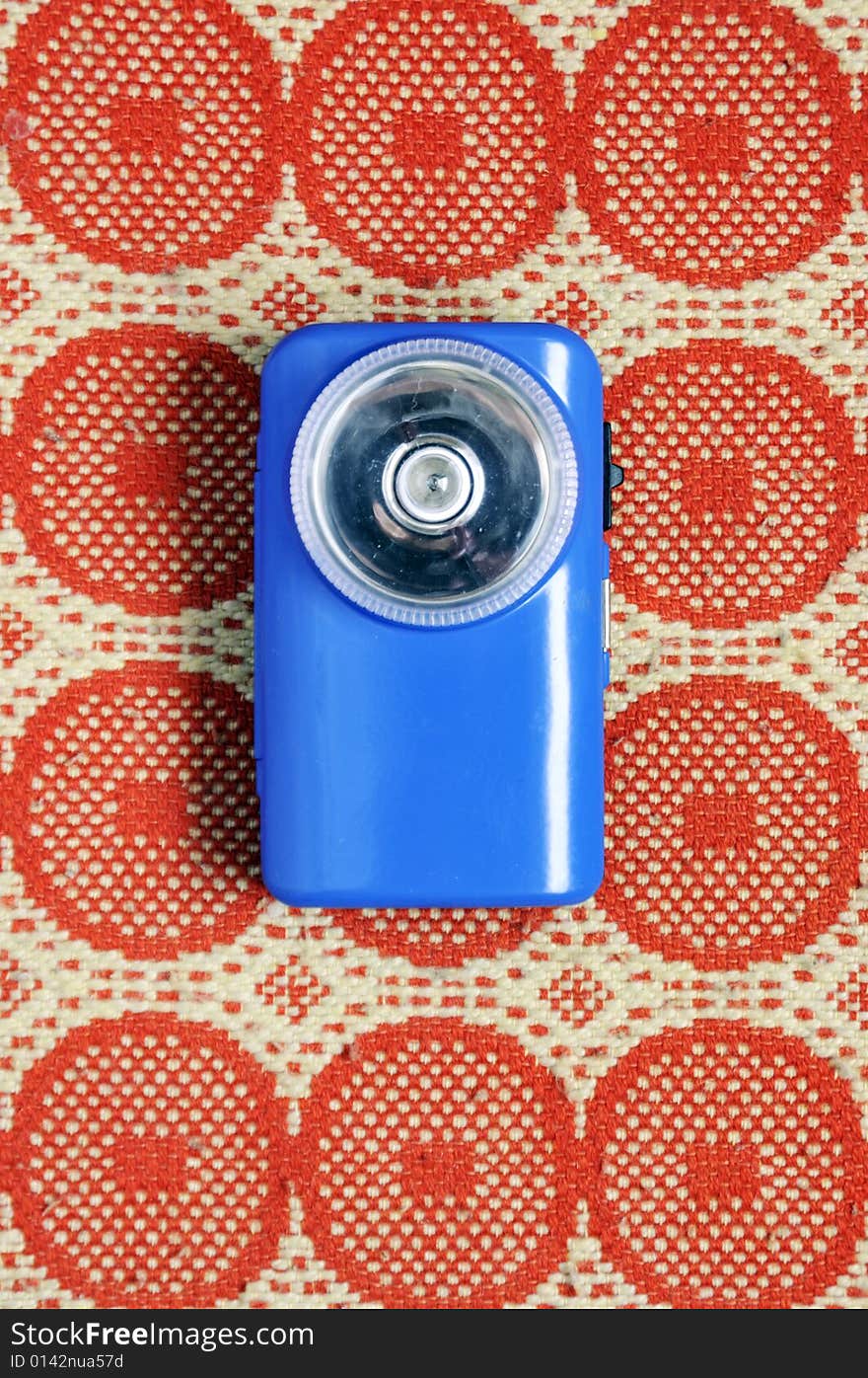 Vintage blue flashlight laying on the carpet