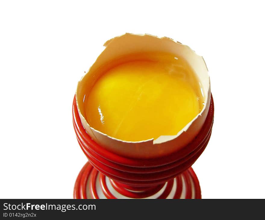 Broken egg in a egg cup on white background. Broken egg in a egg cup on white background