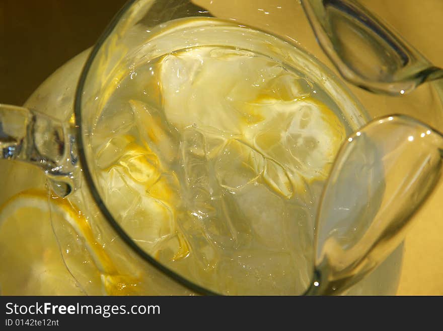 Pitcher of lemonade with lemon slices and ice cubes