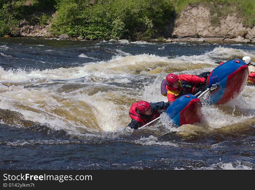 Sportsmen on the blue catamaran in the rapid