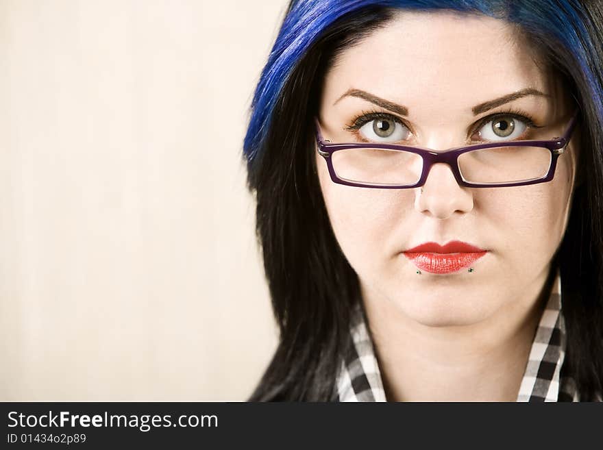 Portrait of a cute rockabilly woman looking over her glasses. Portrait of a cute rockabilly woman looking over her glasses