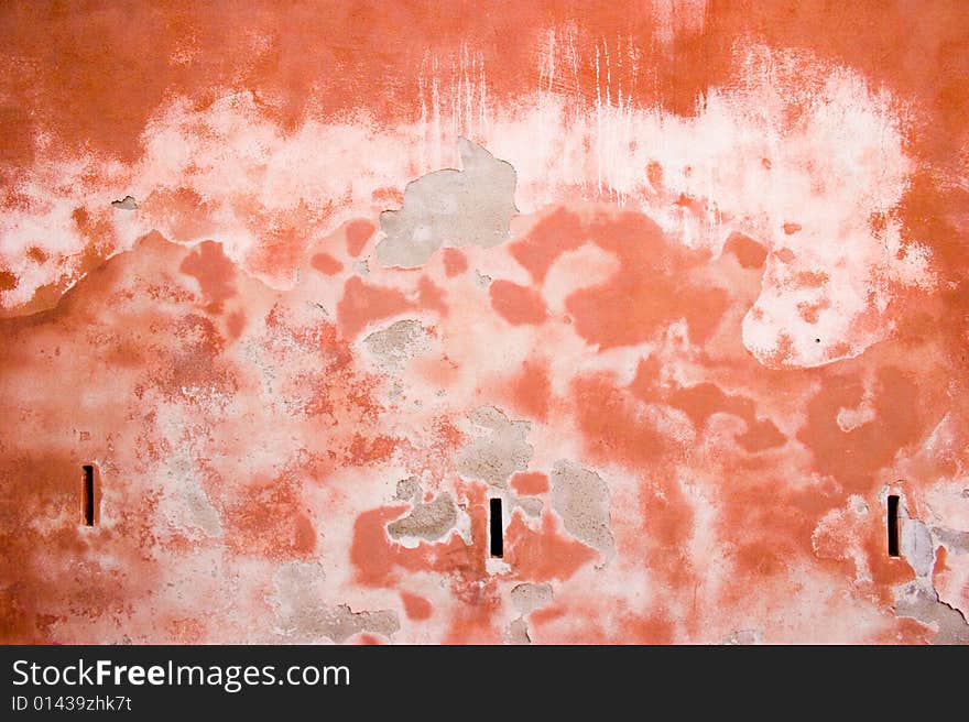 Closeup of red-brown old wall with peeled stucco and stains. Closeup of red-brown old wall with peeled stucco and stains