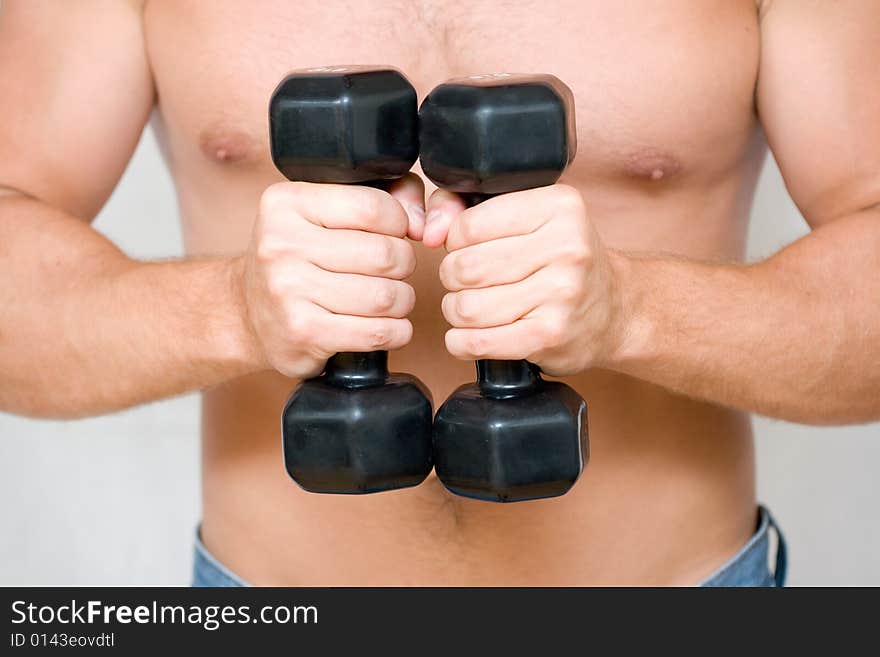 Young man with black dumbbells. Young man with black dumbbells