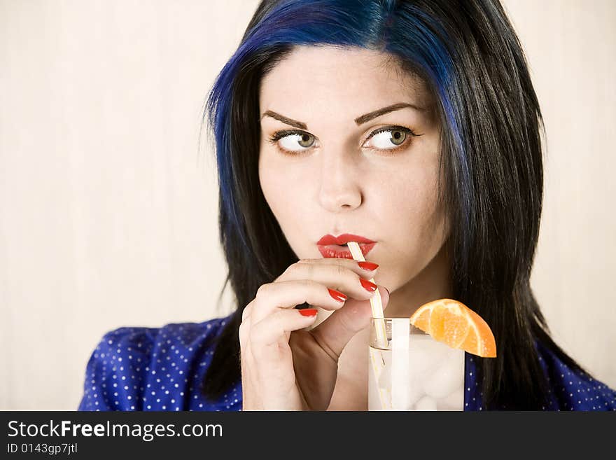 Pretty woman sipping cocktail through a bendable straw. Pretty woman sipping cocktail through a bendable straw