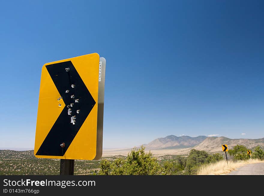 Gun Shot Holes Through A Rural Road Sign