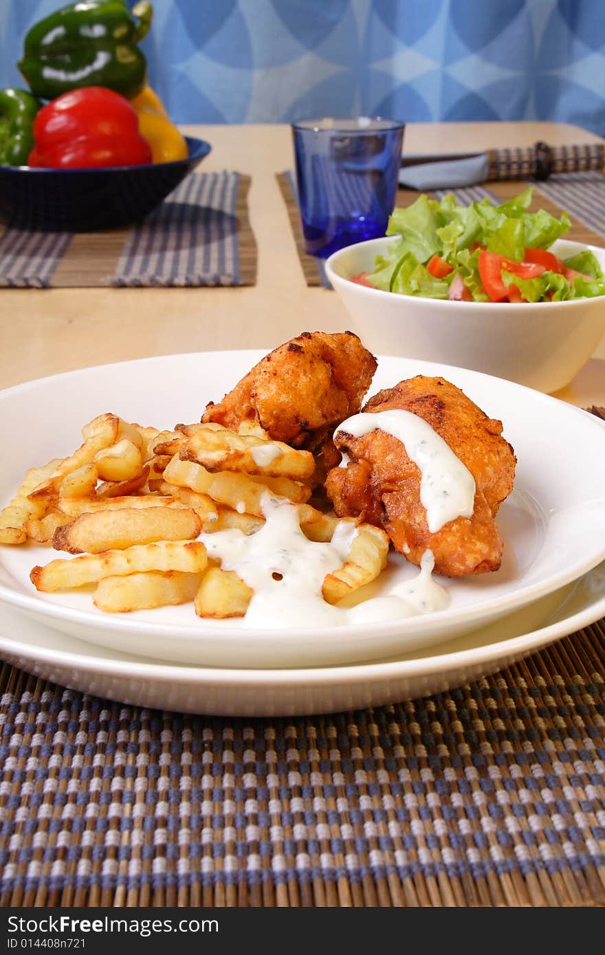 French fries and chicken legs on the plate with garlic sauce