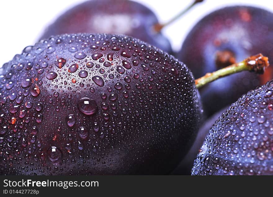 Close-up of wet plums on white background