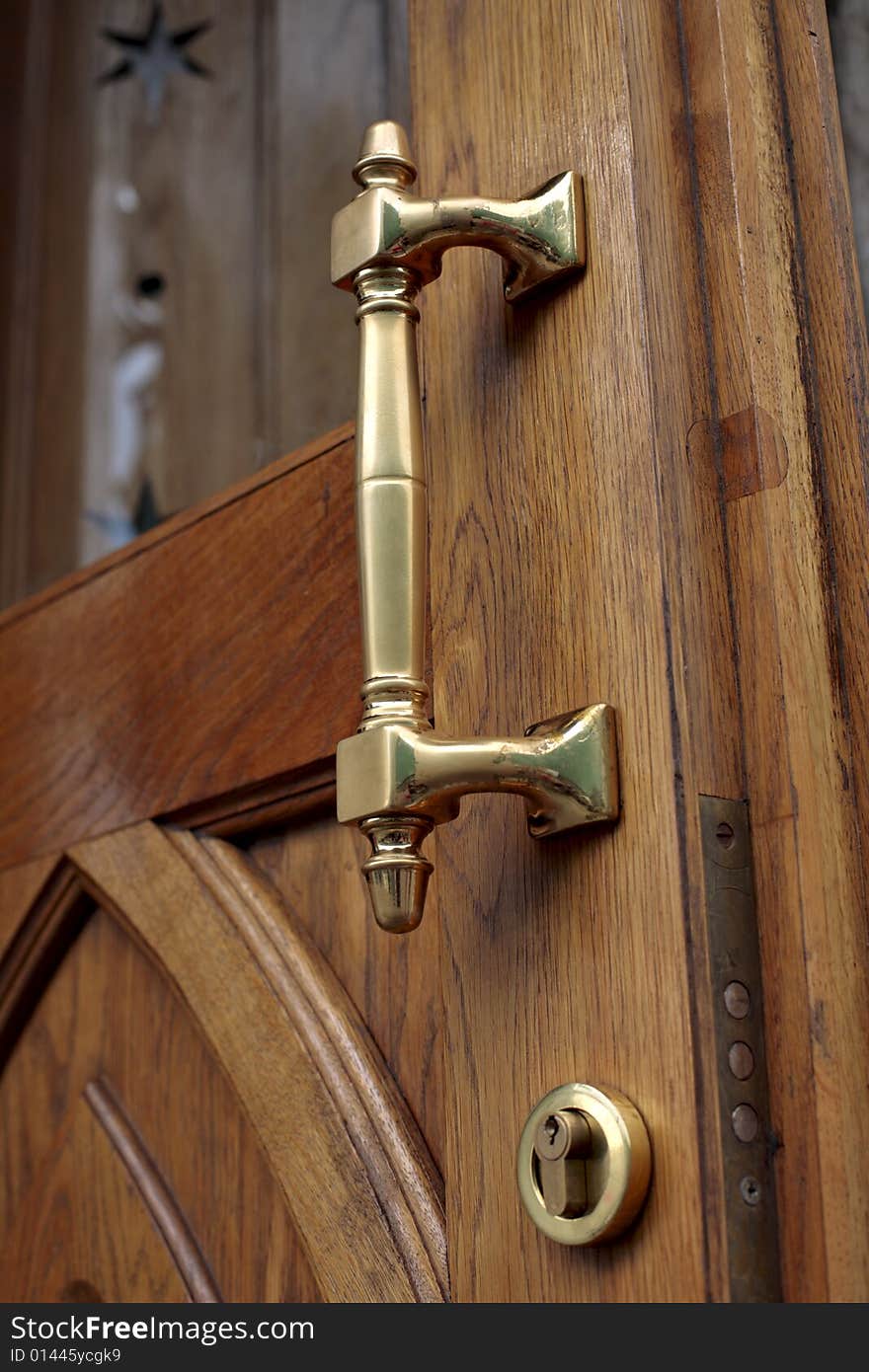 Rubbed brass handle of an old timber door close up. Rubbed brass handle of an old timber door close up