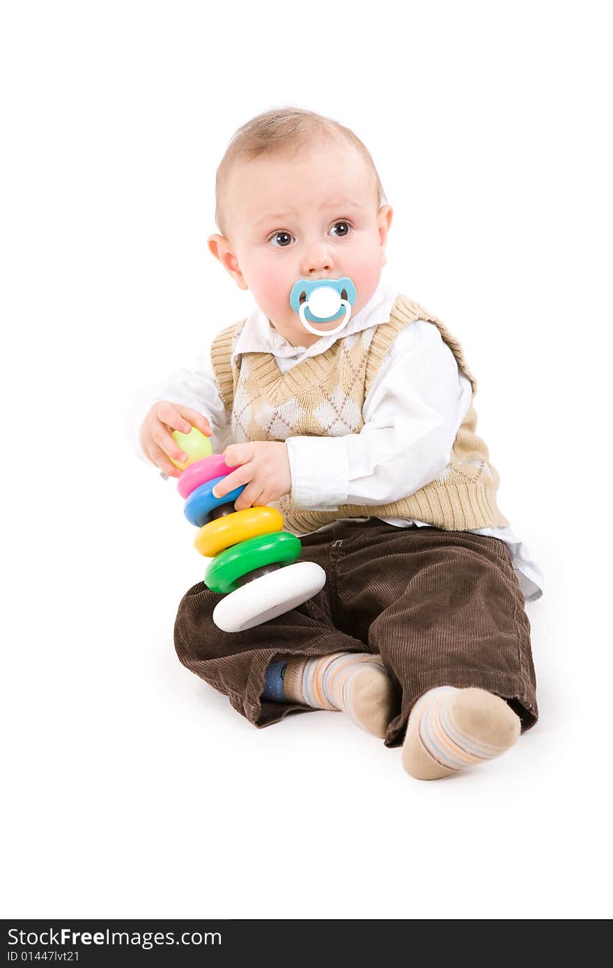 The toddler boy plays developing game. Color pyramidion.