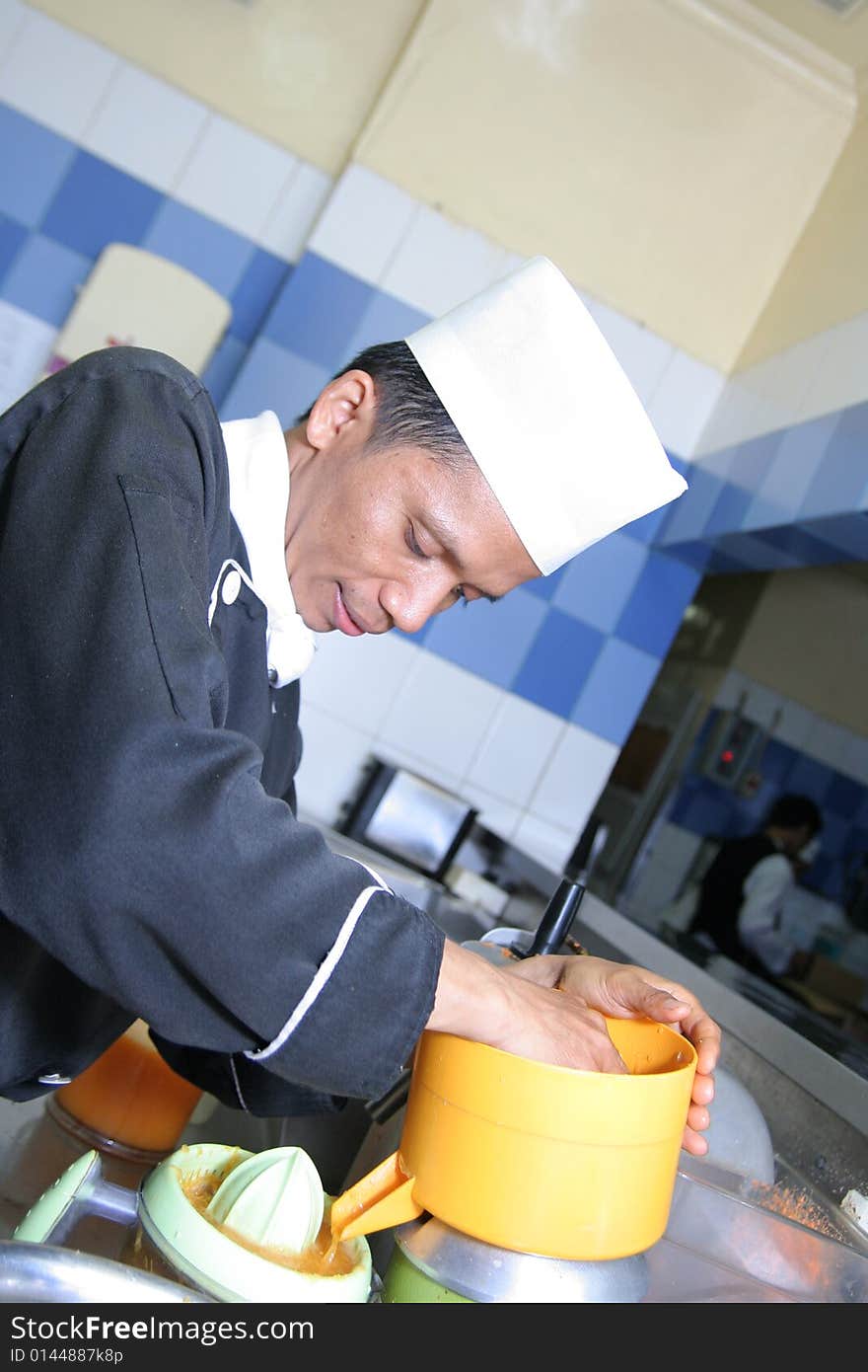 Chef making juice at cold kitchen smiling