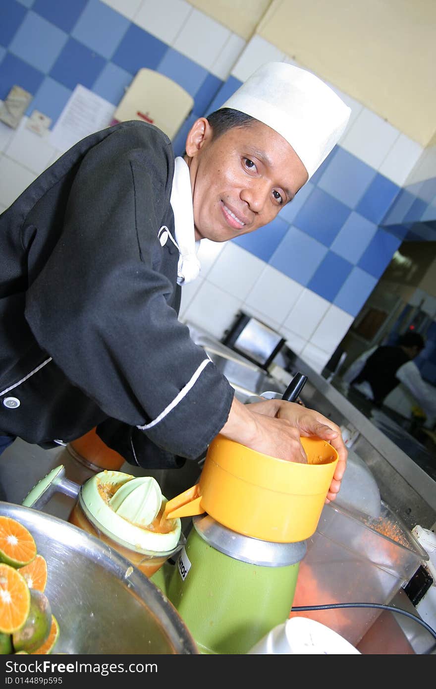 Chef making juice at cold kitchen smiling