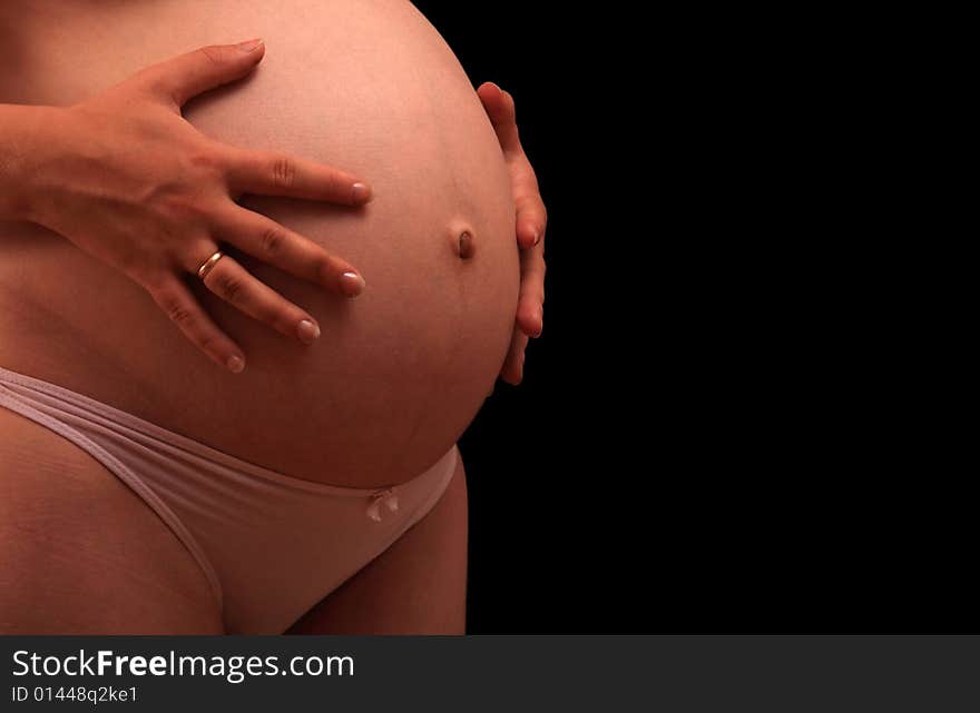 Pregnant woman holding stomach, side view. Pregnant woman holding stomach, side view