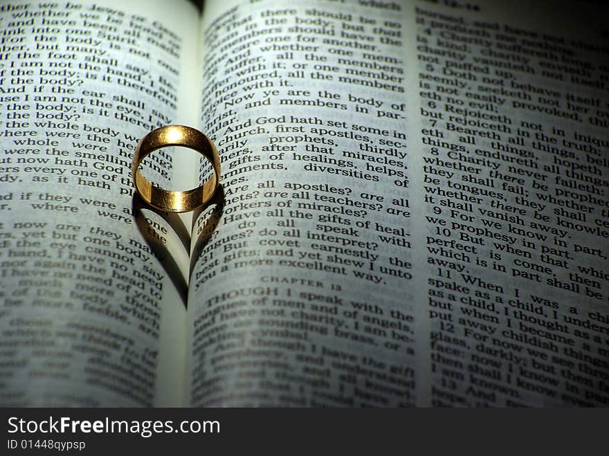 Ring and heart shaped shadow over a Bible. Ring and heart shaped shadow over a Bible