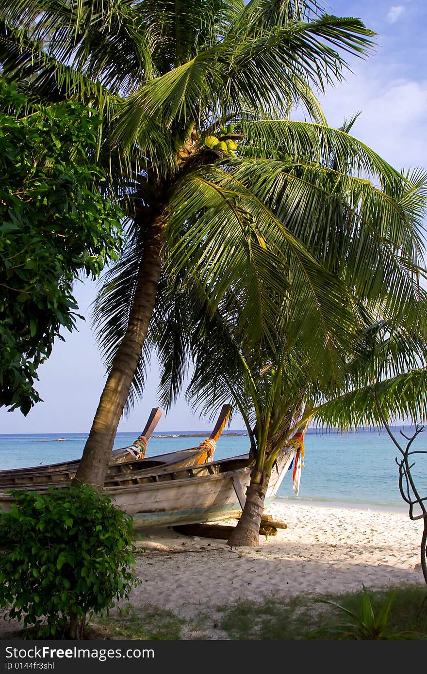 Coco palms on the beach, sand, sky even three lonely boats