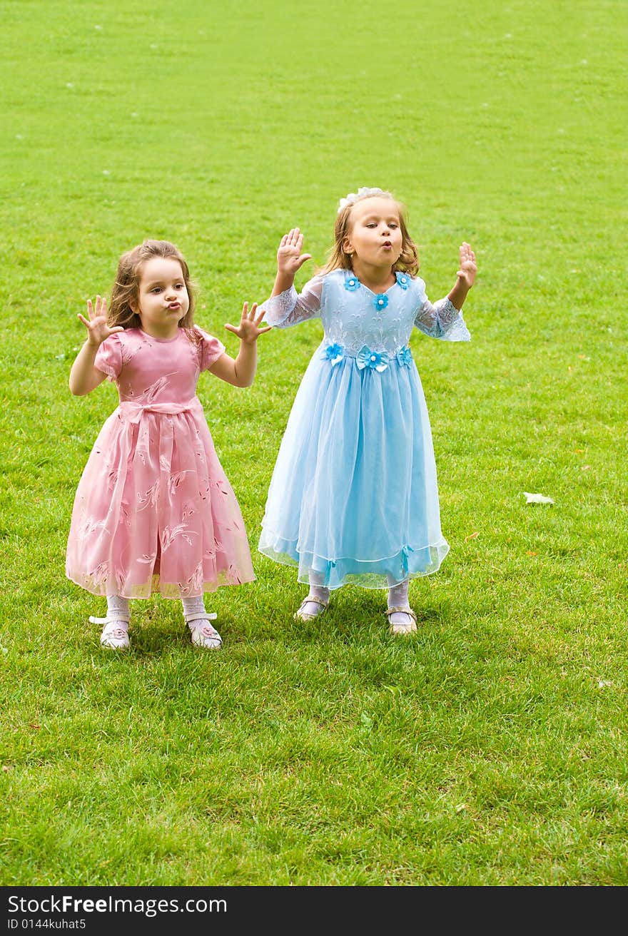 Two little girls are playing on green grass. Two little girls are playing on green grass