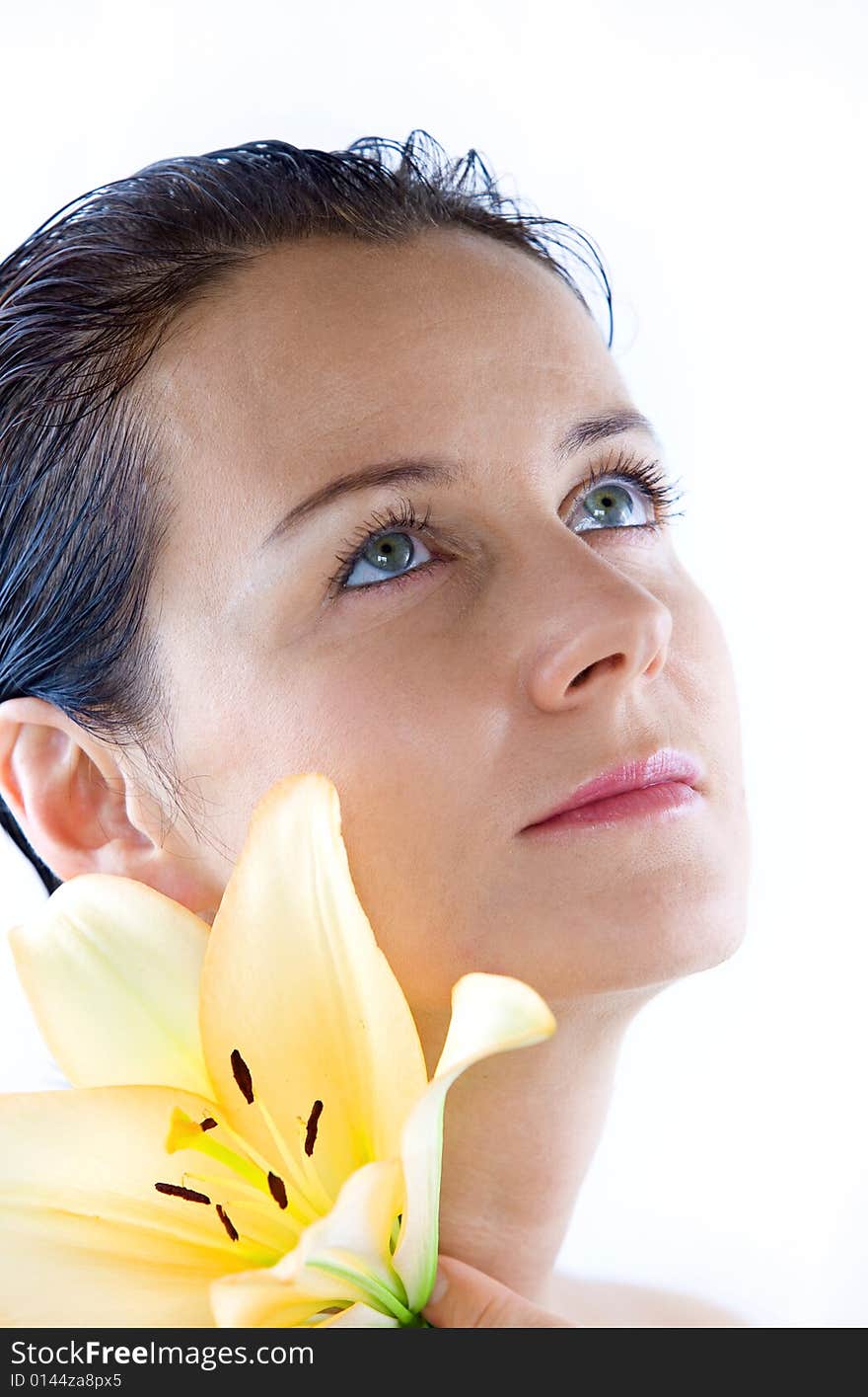 High key portrait of nice brunette with big lily flower. High key portrait of nice brunette with big lily flower