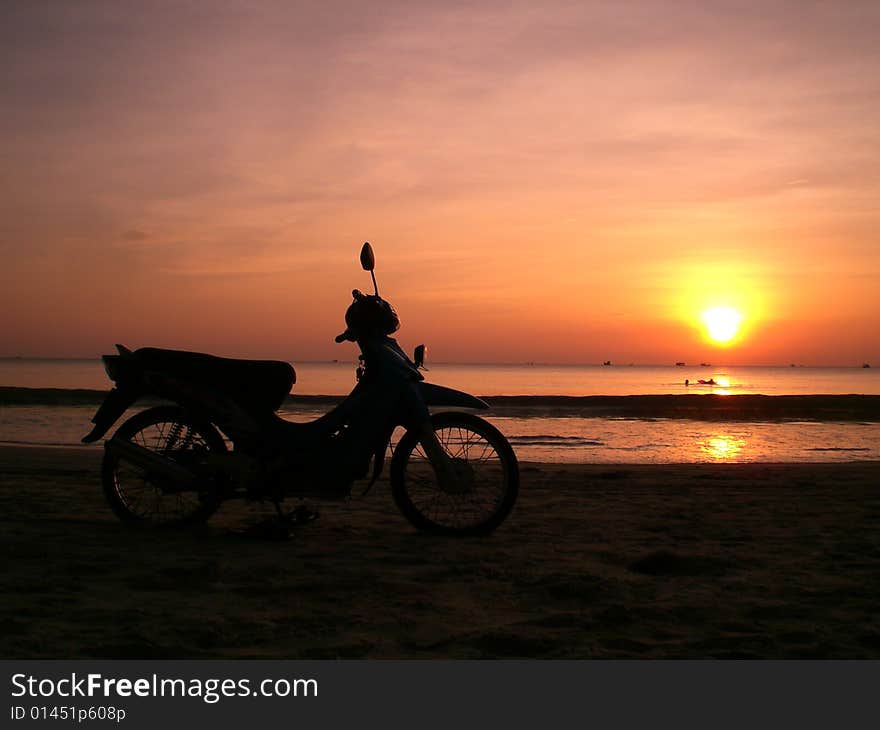 A motor bicycle on the sunset beach. A motor bicycle on the sunset beach