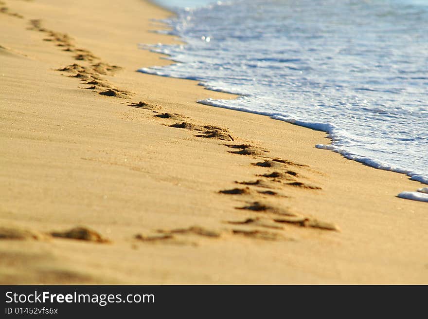 Waves from the Pacific Ocean and footprints along water's edge. Waves from the Pacific Ocean and footprints along water's edge.