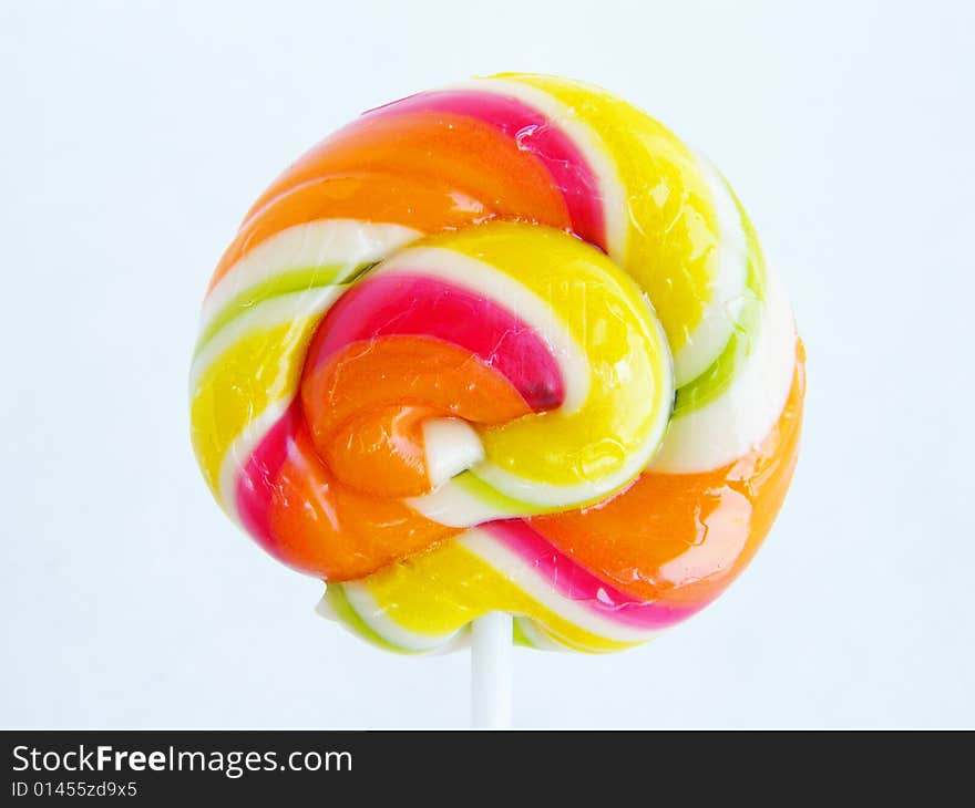 Multi-coloured a sugar candy on a stick on a white background