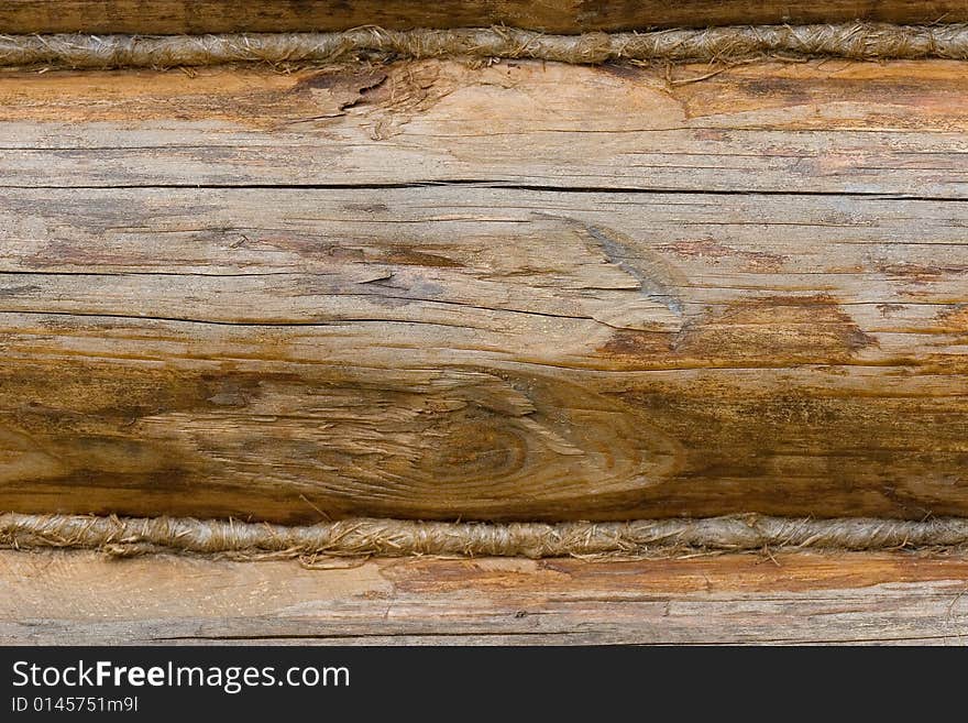 Closeup of an old wooden wall made of logs (as a wooden background)