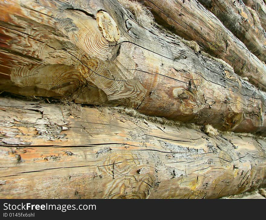 Wall of the house from roughly processed logs. Wall of the house from roughly processed logs