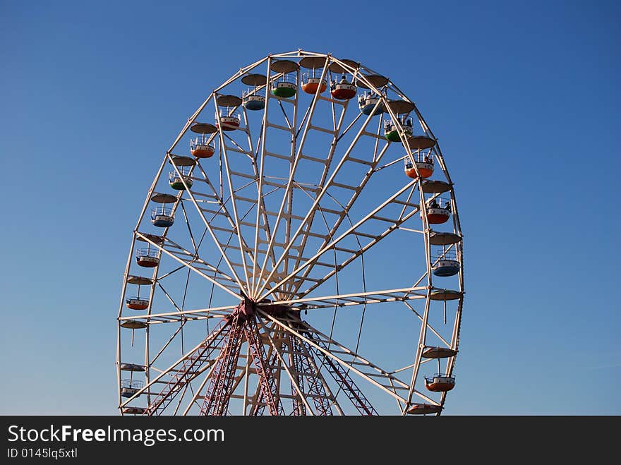 Ferris wheel on background blue sky