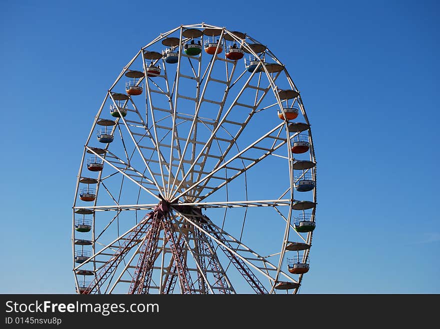 Ferris wheel on background blue sky